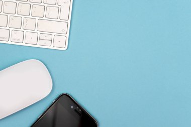 Bir bilgisayar klavyesi ve diğer ofis malzemeleri ile Mavi ofis masası arka plan. Kopyalama alanı ile üst görünüm, düz döşeme.