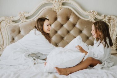 Anne ve kızı yatakta yastık, yastık mücadele mücadele