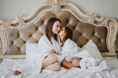 Anne ve kızı yatakta yastık, yastık mücadele mücadele