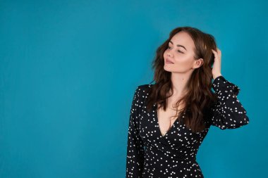 Mavi arka planda güzel bir kız, elbiseli mutlu bir kız.