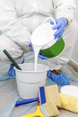 Ressam olan beyaz renk tonunu duvar boyar. Duvar ciddi nem sorunları olan. Ayrıntı fırça. beyaz boya ressamın iş için hazırlanır.