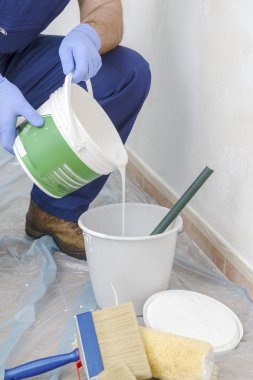 Ressam olan beyaz renk tonunu duvar boyar. Duvar ciddi nem sorunları olan. Ayrıntı fırça. beyaz boya ressamın iş için hazırlanır.