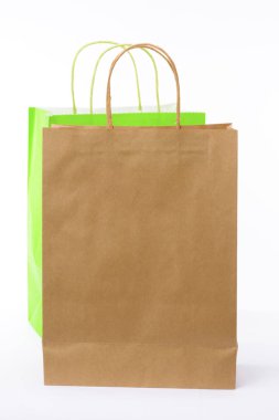 Kahverengi ve yeşil kağıt poşetler beyaz arka plan üzerinde. Boş alan.