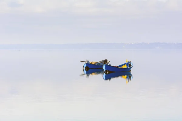 Oude vissersboten met heldere kleuren bij dageraad op het meer. — Stockfoto