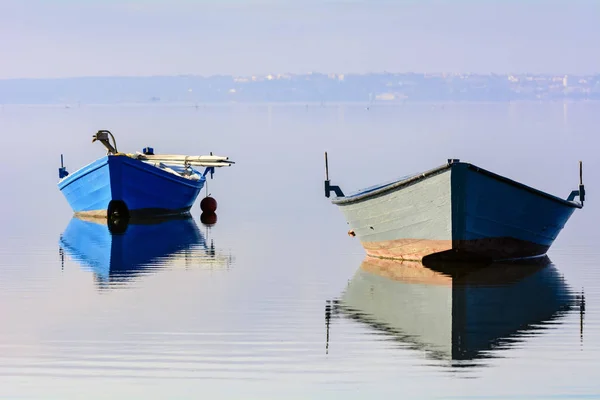 Oude vissersboten met heldere kleuren bij dageraad op het meer. — Stockfoto