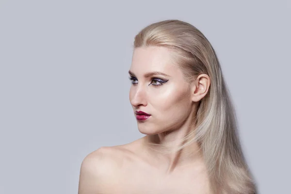 Ein schönes Mädchen mit hellen, natürlichen Haaren schaut zur Seite. Helles Make-up. — Stockfoto