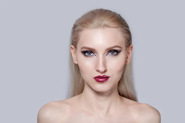 Allvarligt koncentrerat ansikte av flickan blond med ljusa makeup. — Stockfoto