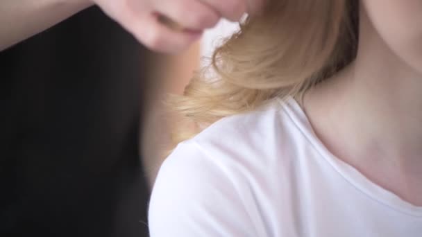 La touche finale dans la coiffure d'une jeune fille. La fille est blonde . — Video