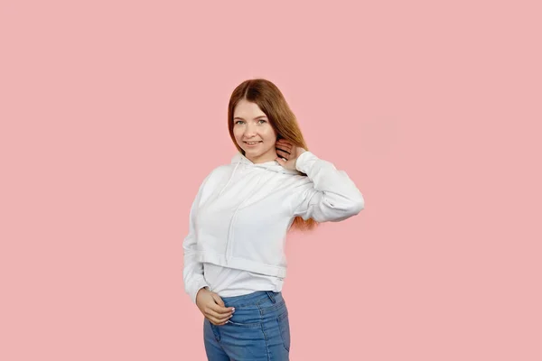 A teenage girl poses and straightens her long hair. — Stock Photo, Image