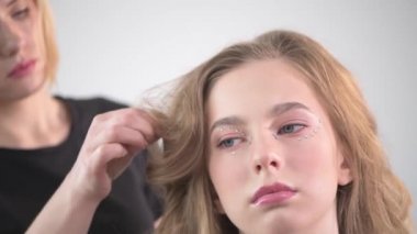 Güzellik salonunda genç ve güzel bir kız. Saç biçimi oluşturuluyor.