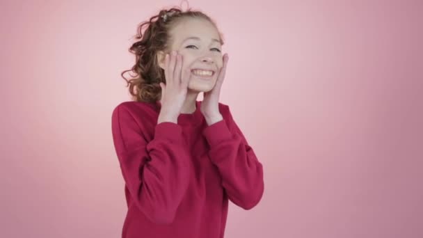 Μια γελαστή έφηβη σηκώνει τα χέρια της στο πρόσωπό της.. — Αρχείο Βίντεο