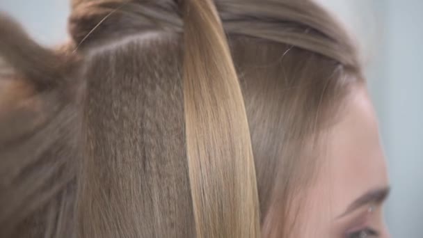 Une belle mèche blanche de cheveux chez une jeune fille. Le fond blanc . — Video