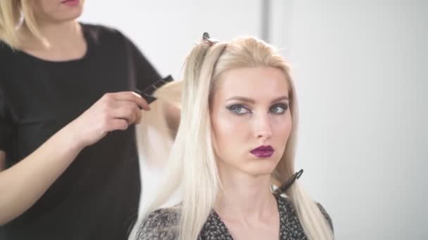 A girl hairdresser does a haircut to a blonde girl. — Stock Video