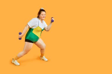 Parlak, neşeli, şişman kız spor yapıyor ve kameraya bakıyor..