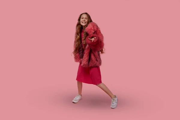 Hermosa chica con el pelo largo y rubio en un abrigo de piel de moda con piel rosa — Foto de Stock