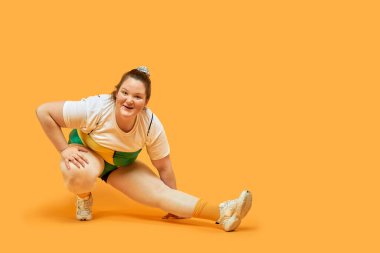 Şişman bir kızın spor yapması egzersiz yaptırıyor. Kilo verme arzusu.