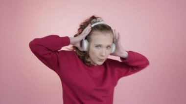 Güzel bir genç kız dans eder, kulaklıkla müzik dinler ve dans eder..