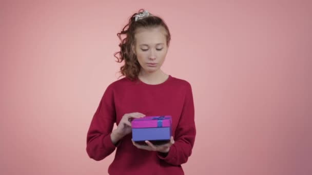 Překvapená radostná dívka otevírá dárky k Vánocům. — Stock video