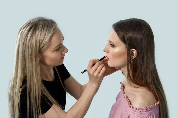 Make-up kunstenaar maakt professionele make-up aan de klant bij haar thuis. — Stockfoto