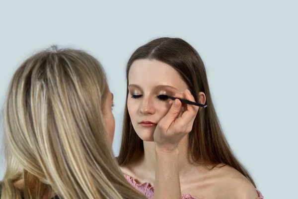Салон красоты. Девушка гример делает макияж клиента . — стоковое фото