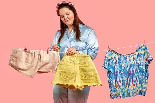 Şişko güzel kız çamaşırlarını asıyor. Büyük beden giysi.