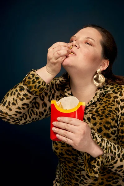 Tlustá holka má velkou chuť na hranolky. Rychlé občerstvení. Koncept nenasytnosti. — Stock fotografie