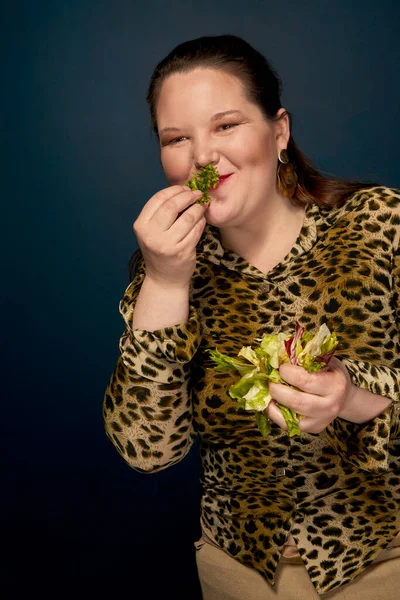 Tlustá holka jí salát, zeleninu. Fotografie ve studiu. — Stock fotografie