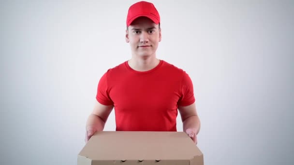 Pizza bezorger, een jonge man, in uniform geeft een gesloten doos pizza. — Stockvideo