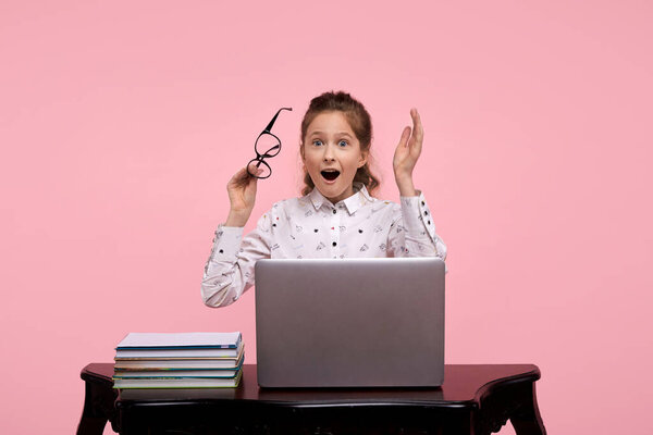 Красивой девушке в белой рубашке пришла в голову замечательная идея. Девушка сидит за ноутбуком
