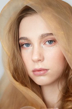 Güzel, temiz bir yüzü olan, kafası örtülü genç bir kız..