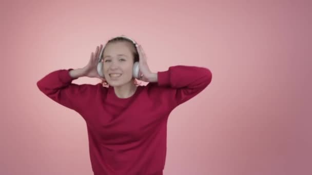 Een jong meisje geniet van een muziek in een koptelefoon. — Stockvideo