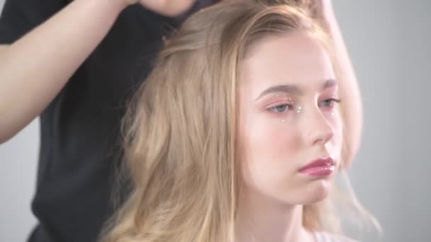 En ung vacker flicka i en skönhetssalong. Skapa frisyrer. — Stockvideo