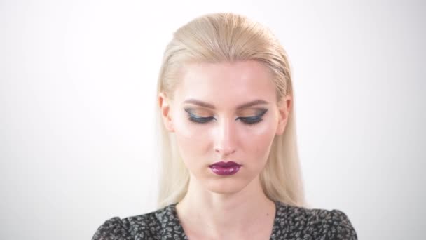 A beautiful young girl with festive make-up looks down and opens her eyes. — Stock Video
