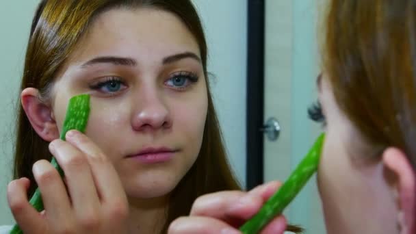 Frau benutzt Aloe-Vera-Blatt und schaut in den Spiegel — Stockvideo