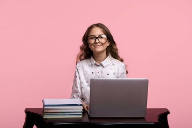 Uzun saçlı güzel bir kız internette ders çalışıyor.