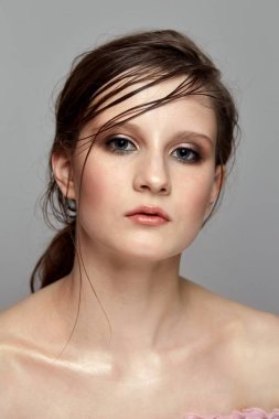 Hassas makyajlı ve ıslak saçlı profesyonel bir model..