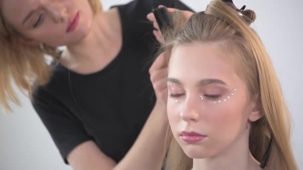 Close-up van een jong meisje met delicate make-up in een schoonheidssalon. — Stockvideo
