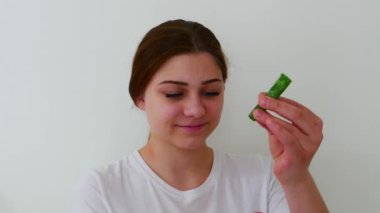 Aloe vera yaprağını meyve suyuyla tutan güzel bir kızın portresi.