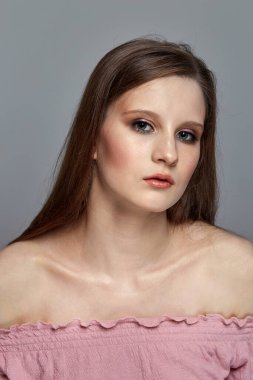 Genç esmer bir kızda güzel, parlak bir makyaj. Yüzü yakın çekim.