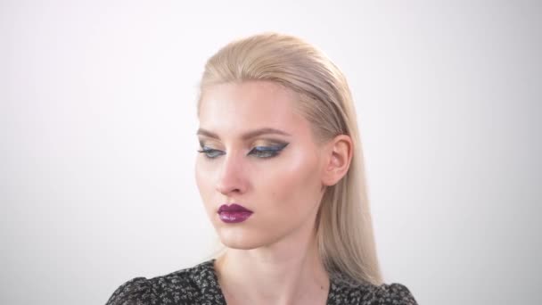 Mooi goed verzorgd gezicht van een jong blond meisje met heldere make-up. — Stockvideo