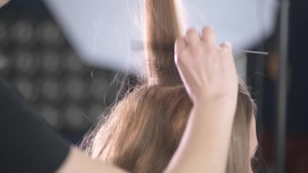 Une jeune belle fille dans un salon de beauté. Création de coiffures . — Video