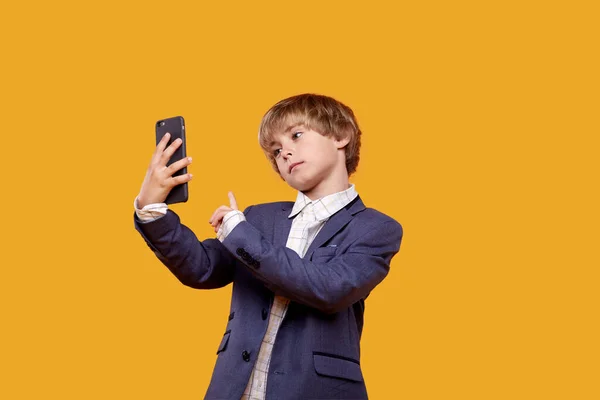 귀여운 작고 귀여운 소년 이 휴대 전화를 들고 셀카를 들고 간다. — 스톡 사진