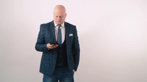Un hombre adulto con una chaqueta habla por teléfono con desconcierto en la cara . — Vídeos de Stock