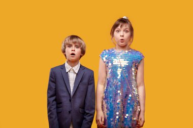 Ağızları açık, şen şakrak giyinmiş iki şirin çocuk..