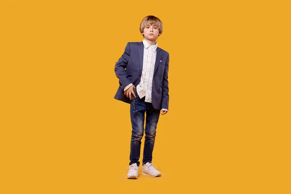 En liten pojke är en lång blond pojke i jacka och jeans. — Stockfoto