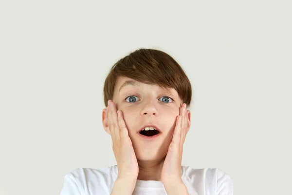 Een jongen met een bang gezicht kijkt in de camera. — Stockfoto
