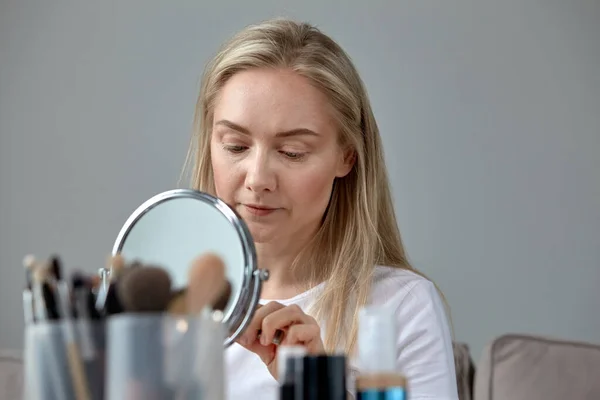 Mulher loira bonita faz-se uma maquilhagem escova cosmética — Fotografia de Stock