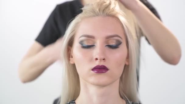 En tjej klient med ljus makeup och en frisör. — Stockvideo