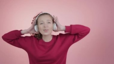 Genç bir kız kulaklıkla müzik dinlemekten hoşlanır..