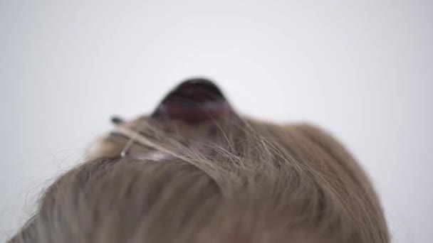 Detailní záběr vlasů krásné mladé dívky na bílém pozadí. — Stock video